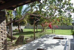 Surrounded by lush greenery, this outdoor patio offers a serene escape.