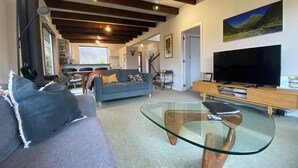 A modern living room with a sofa, glass coffee table, and a flat-screen TV.