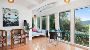 Una habitación amplia con un gran ventanal, un comedor y una zona de estar acogedora con una cama.
