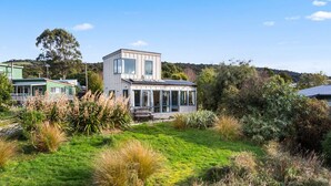 Una casa moderna con un amplio ventanal y un jardín espacioso.