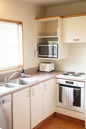 Cocina compacta con pileta, tostadora, microondas y horno.