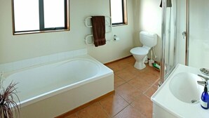 Un baño con bañera, inodoro y lavabo.