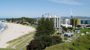Zona costera con playa, edificios y una grúa de construcción.