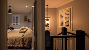 Un dormitorio con una cama, una mesita de noche, una lámpara y un cuadro en la pared.