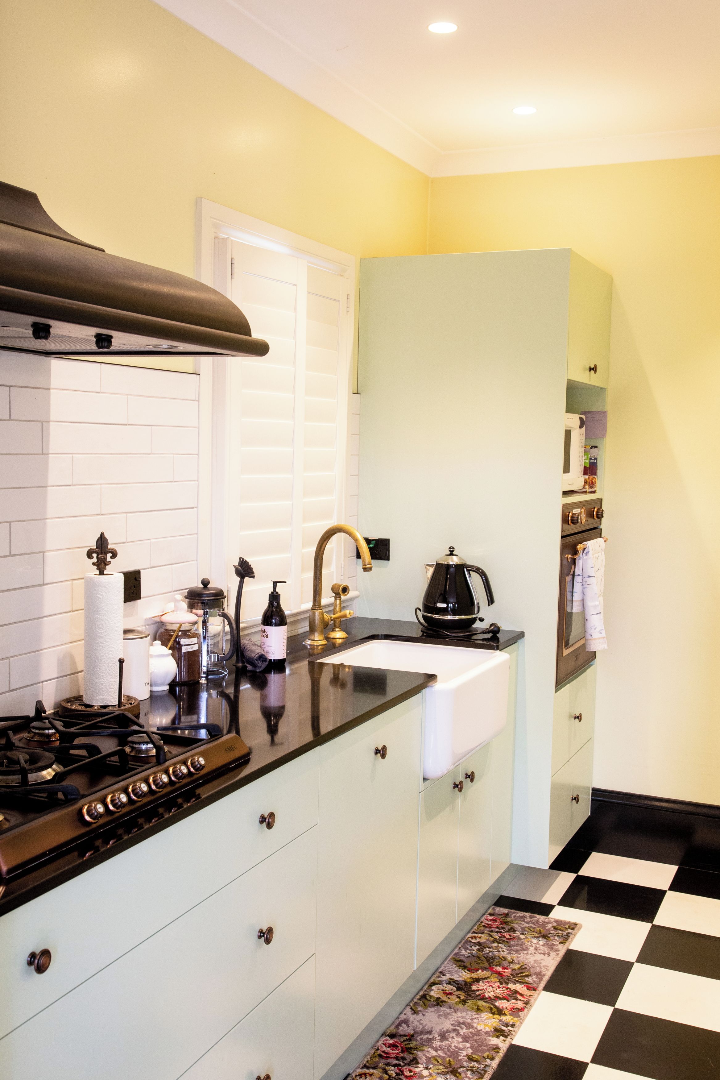 Una cocina con estufa, lavaplatos y cafetera.