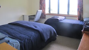 A room with two beds, a desk, and a chair.