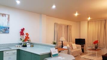 Una sala de estar moderna con sofá, televisor y comedor.