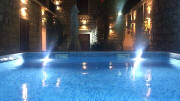 Een buitenzwembad, ligstoelen bij het zwembad