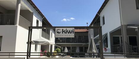 En byggnad med en skylt där det står "Kiwi Apartments".