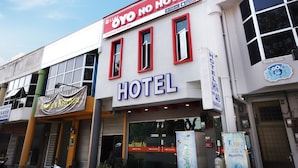 A hotel with a prominent red and white sign, large windows, and a visible entrance.
