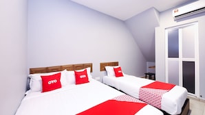 A hotel room with two beds, each with white bedding and red accents, a wooden headboard, and a large window with a view.