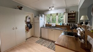 Una cocina compacta con refrigerador, lavamanos y armarios de madera.