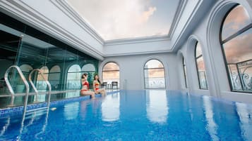Una piscina al aire libre, sombrillas, sillones reclinables de piscina