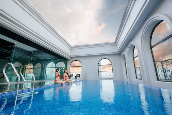 Una piscina al aire libre, sombrillas, sillones reclinables de piscina