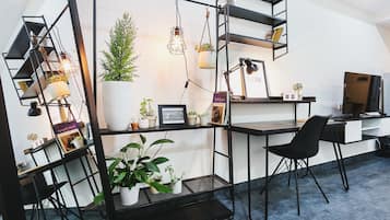 Un espace de bureau moderne comprenant un bureau, une chaise, des étagères et des plantes en pot.