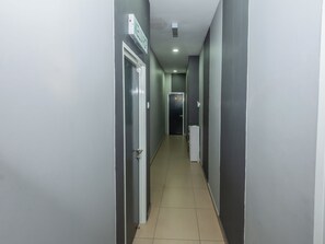 Un pasillo con puertas, un letrero y un dispensador de agua.