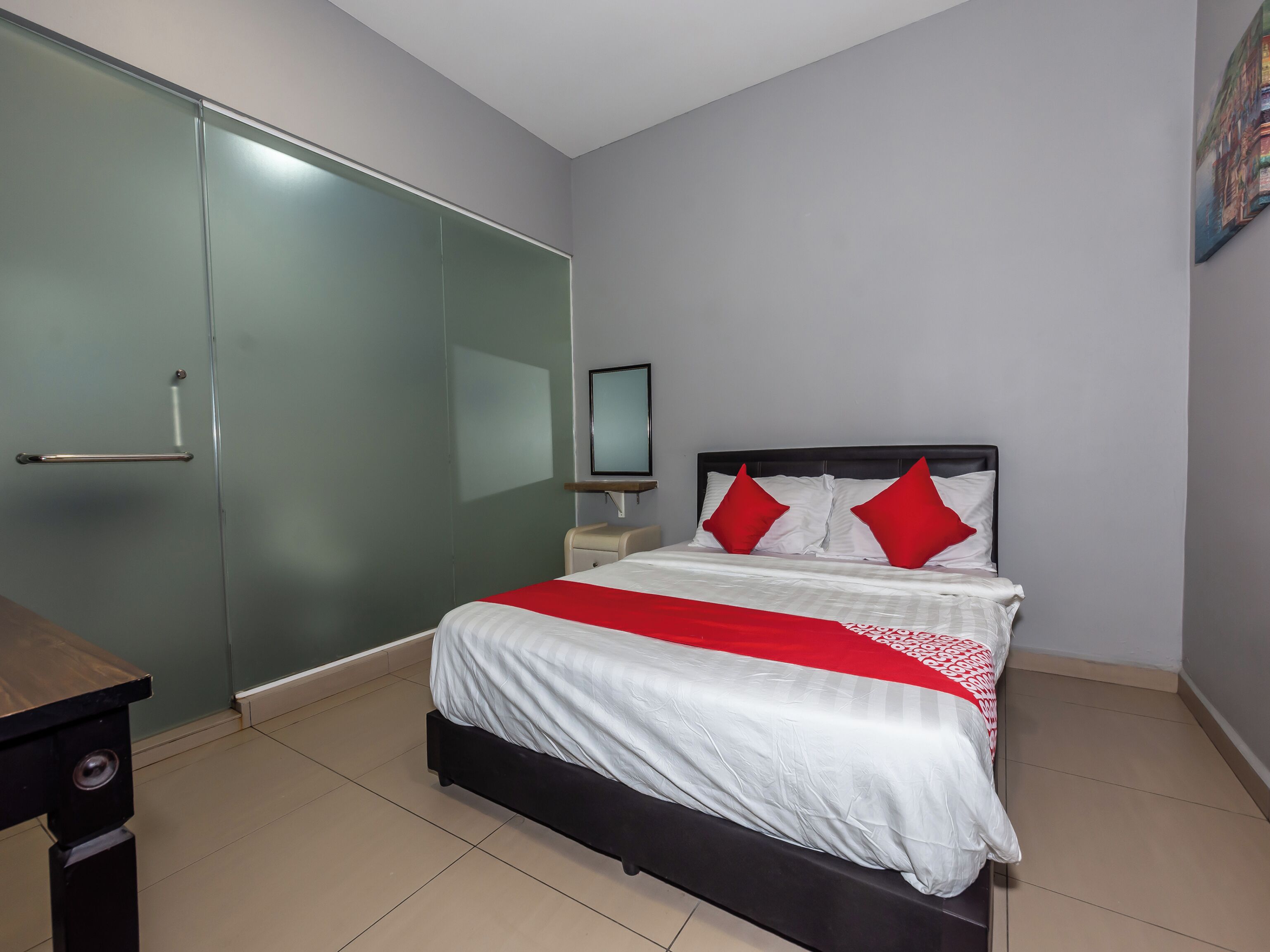 A bedroom with a bed, a bedside table, a wardrobe, and a television.