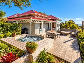 A house with a covered patio, a hot tub, and outdoor furniture. - Crescent Villa - Palm Beach Views & Hot Tub (Palm Beach)
