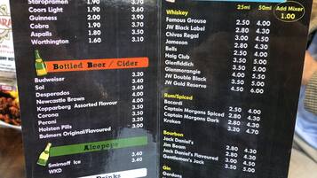 Un menú con diversas opciones de bebidas, incluyendo cerveza de barril, sidra, bebidas no alcohólicas, licores y refrescos.