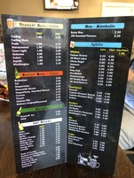 Un menú con diversas opciones de bebidas, incluyendo cerveza de barril, sidra, bebidas no alcohólicas, licores y refrescos.