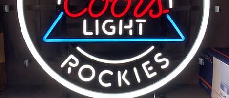 Une enseigne au néon avec les inscriptions « Né dans les Rocheuses » et « Coors Light » sur un fond circulaire.