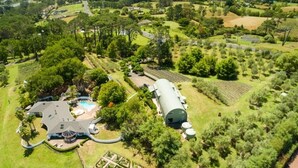 Vue aérienne d’un vaste domaine comprenant une maison remarquable, une piscine et de vastes jardins.