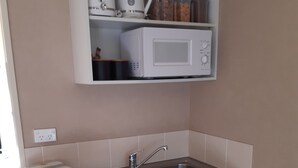 A compact kitchen with a built-in microwave, a sink, and a small refrigerator. - Free Wifi/Breakfast,clean,private studio Greymouth (Greymouth)