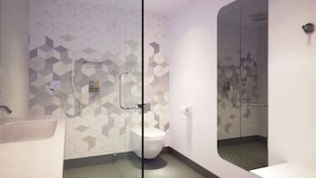 A modern bathroom with a glass shower enclosure, a toilet, and a sink.