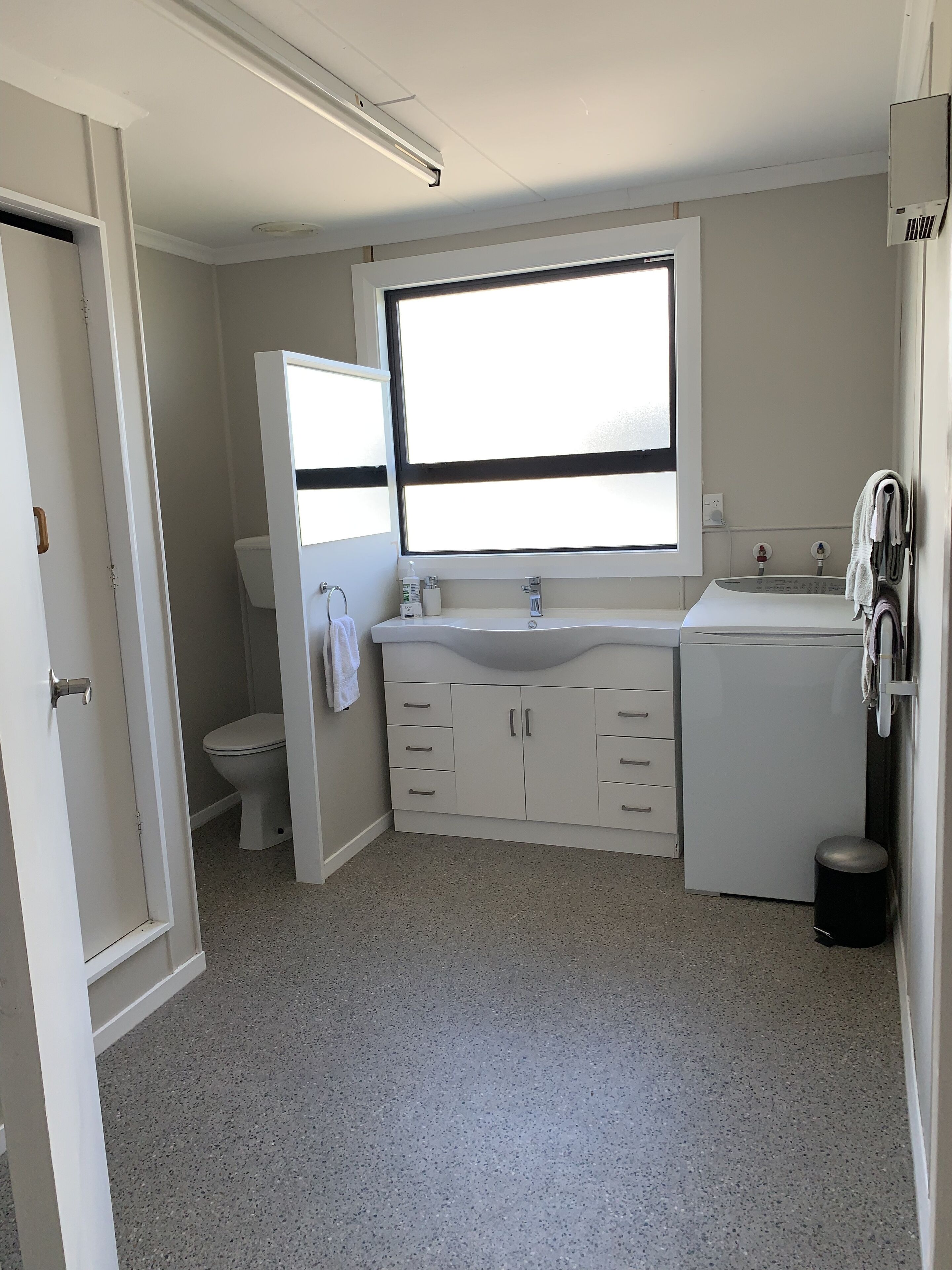 A bathroom with a toilet, sink, and mirror.
