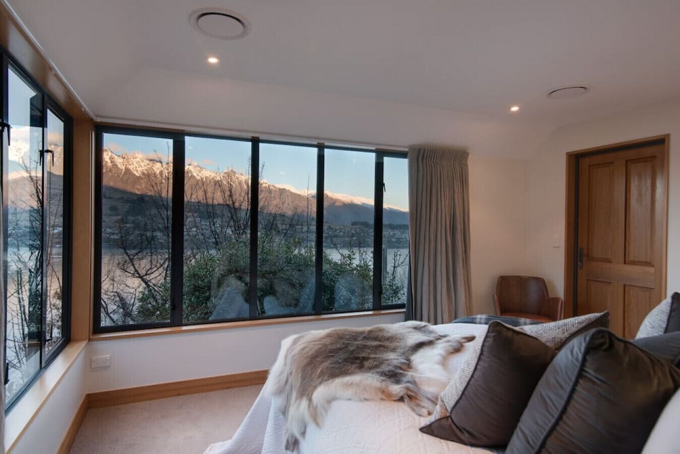 A bedroom with a large window offering a mountain view.