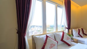 A hotel room with a bed, pillows, and a window with curtains. - Lien Son Hotel Da Lat (Xuan Huong - Da Lat)