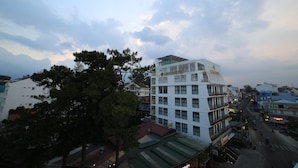 A multi-story hotel with a modern design, featuring a prominent sign at the top. - Lien Son Hotel Da Lat (Xuan Huong - Da Lat)