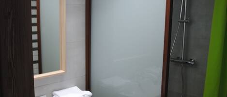 A modern bathroom with a skylight, a glass shower enclosure, and a wooden vanity.