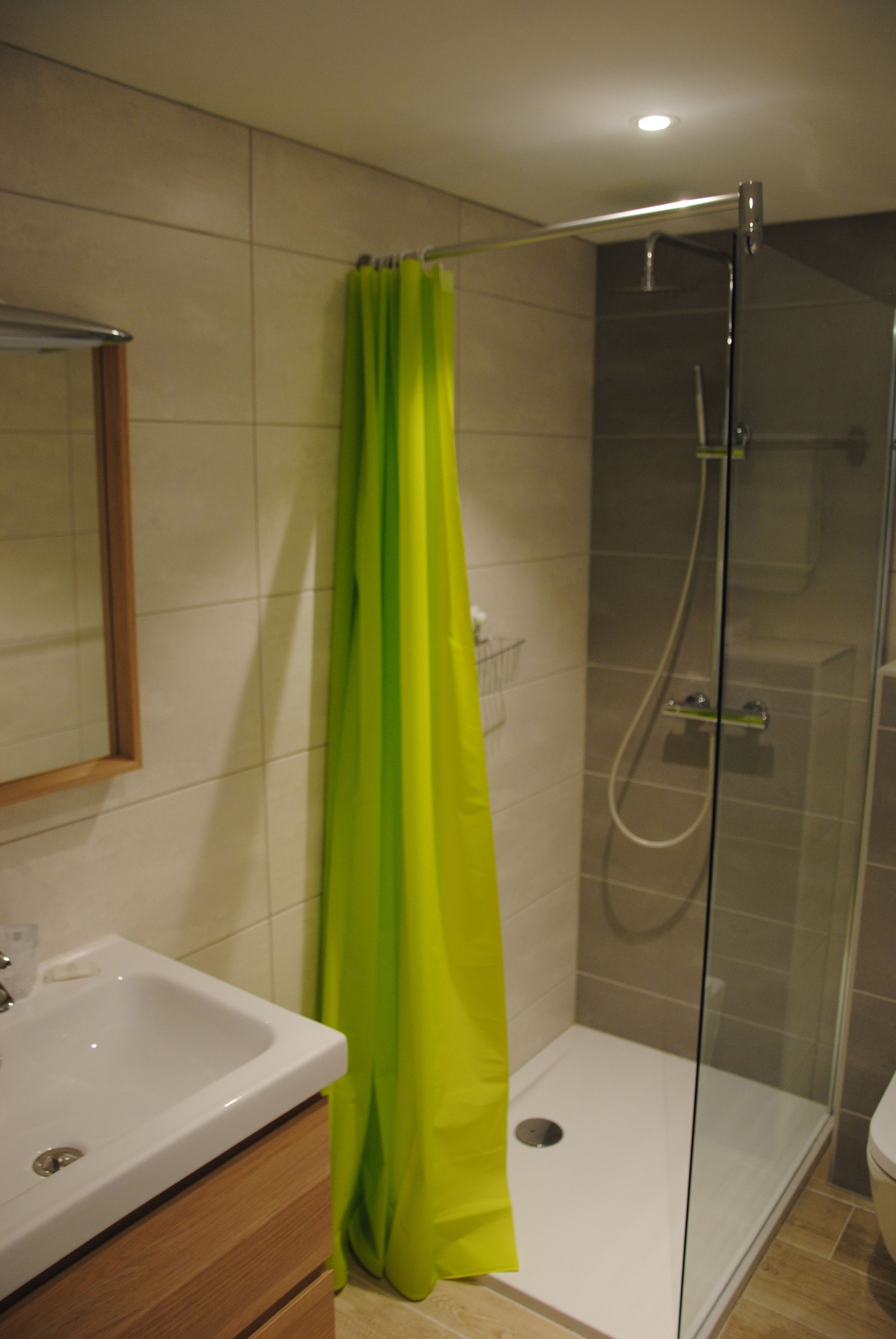 Une salle de bain avec une douche, un lavabo et des toilettes.