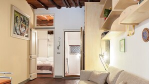 A cozy room with a bed, a sofa, and a wooden ceiling. - San Lorenzo Apartment (Florence)