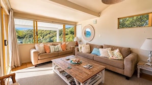 A living room with two sofas, a coffee table, and a large window with a view of greenery. - Island View - Walk to Palm Beach (Palm Beach)