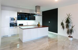 Enjoy cooking in this kitchen with a sleek island, oven, microwave, and range hood.