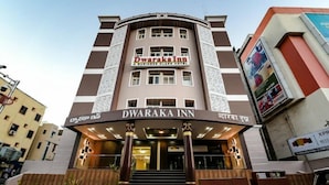 L’extérieur de l’hôtel Dwaraka Inn se distingue par son entrée imposante et un escalier menant à cette entrée.
