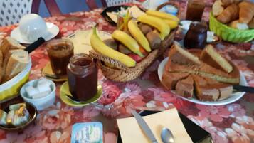 A table with various food items including bread, bananas, and a chocolate spread.
