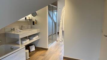 Un baño moderno con lavamanos de mármol, bañera y cabina de ducha de vidrio.