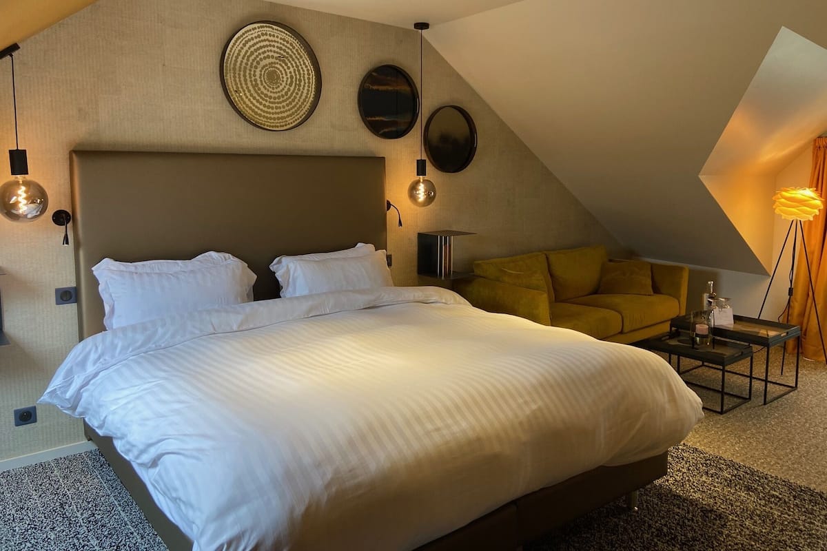 Un dormitorio moderno con una cama grande, un sofá y una mesita.