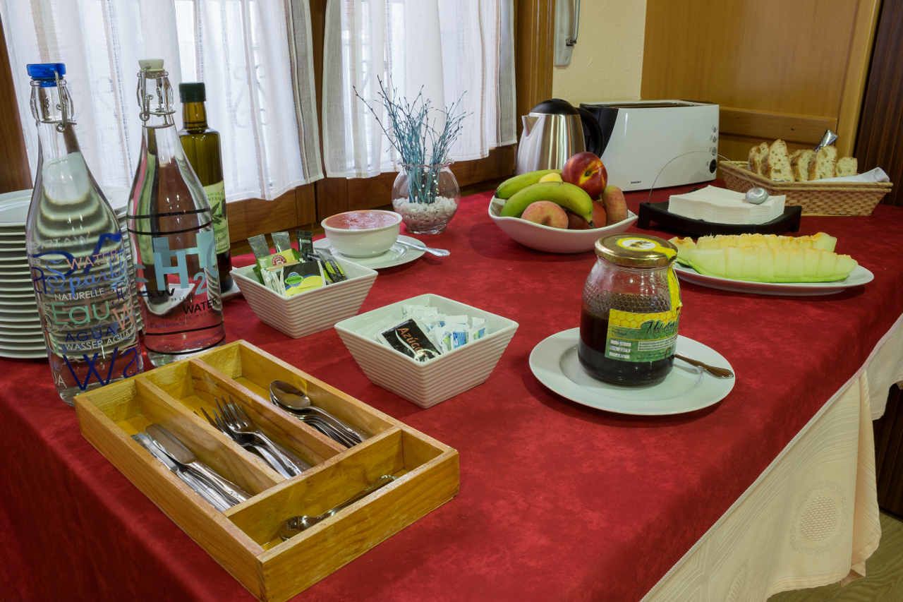 A breakfast buffet setup with various food items, condiments, and utensils.