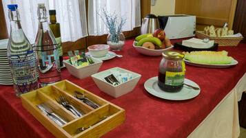 A breakfast buffet setup with various food items, condiments, and utensils.