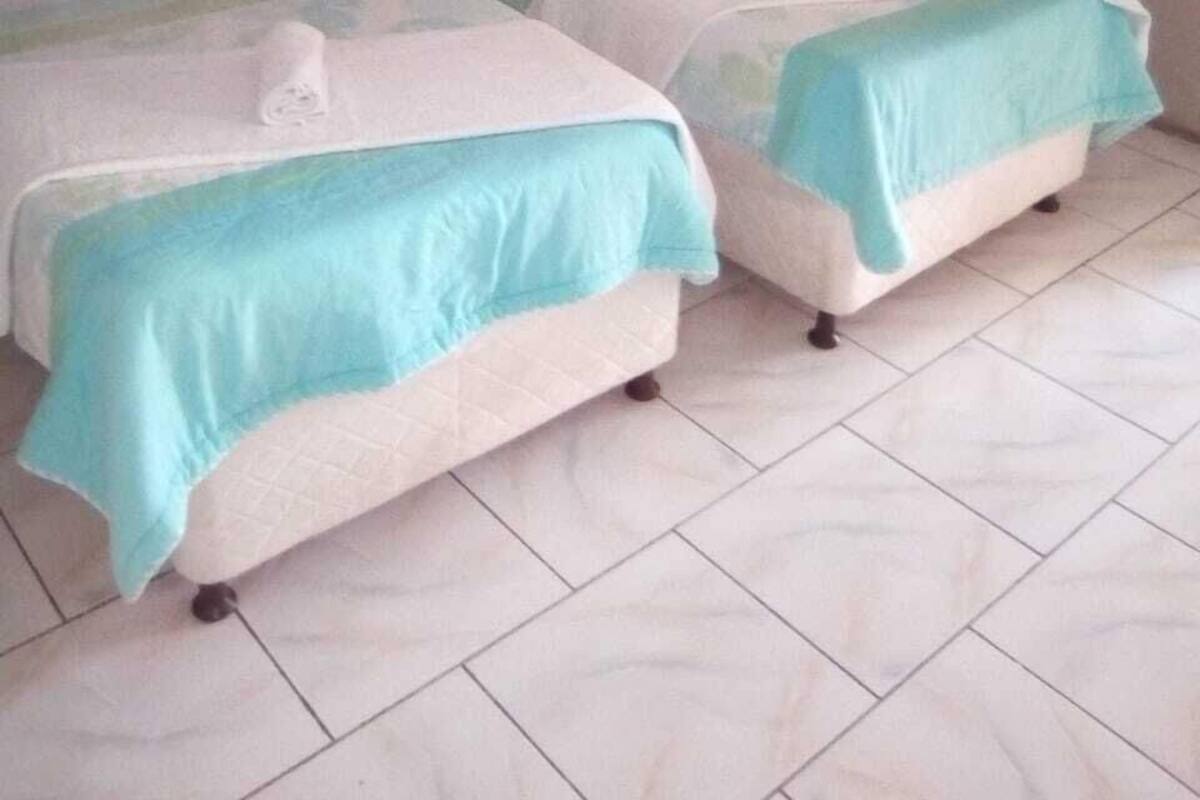 Habitación con 2 camas individuales | Tabla de planchar con plancha y ropa de cama
