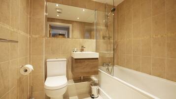 A modern bathroom with a toilet, sink, and shower.