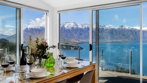 A dining table with a view of a lake and mountains. - 9b on Von - Breath-taking Views (Queenstown)