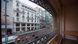 A view from inside a building, looking out through a window with a metal railing. -  Room Gran Vía (Madrid)