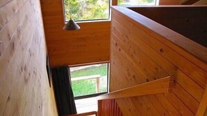 A wooden interior with a staircase leading to a balcony. - Arawa Escape - Ohakune Holiday Home (Ohakune)