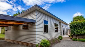 A modern single-story house with a covered porch, a gravel driveway, and a well-maintained garden. - 1 bedroom Restful retreat w/Spa for couples (Ohakune)