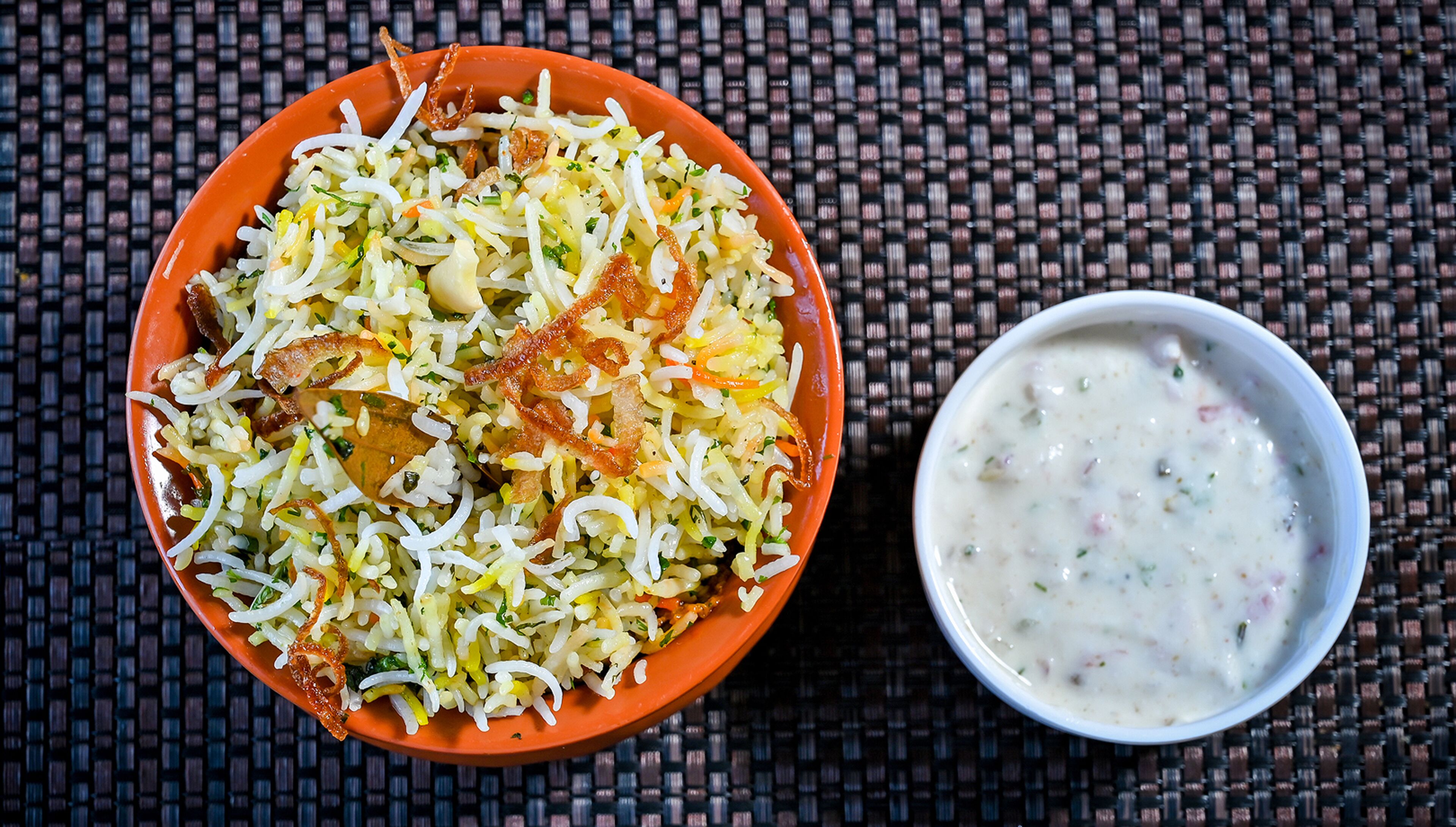 Un plato de biryani y un plato de raita.